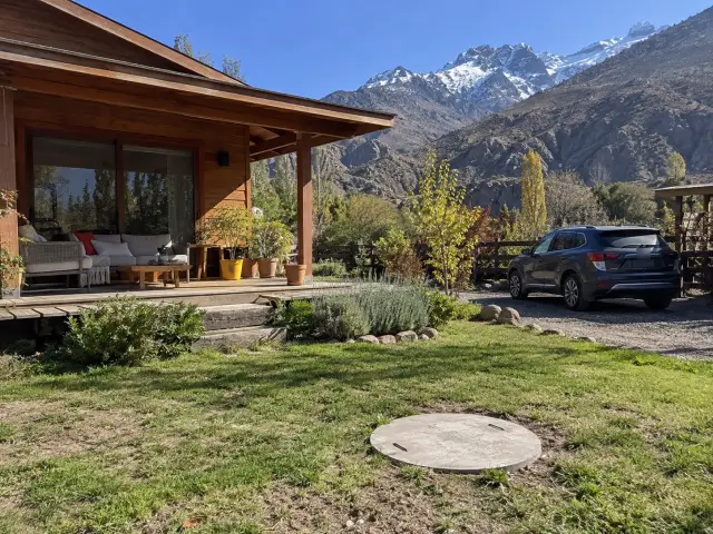 Casa de madera de fin de semana en el Cajón del Maipo, con la tapa de la fosa en el pasto